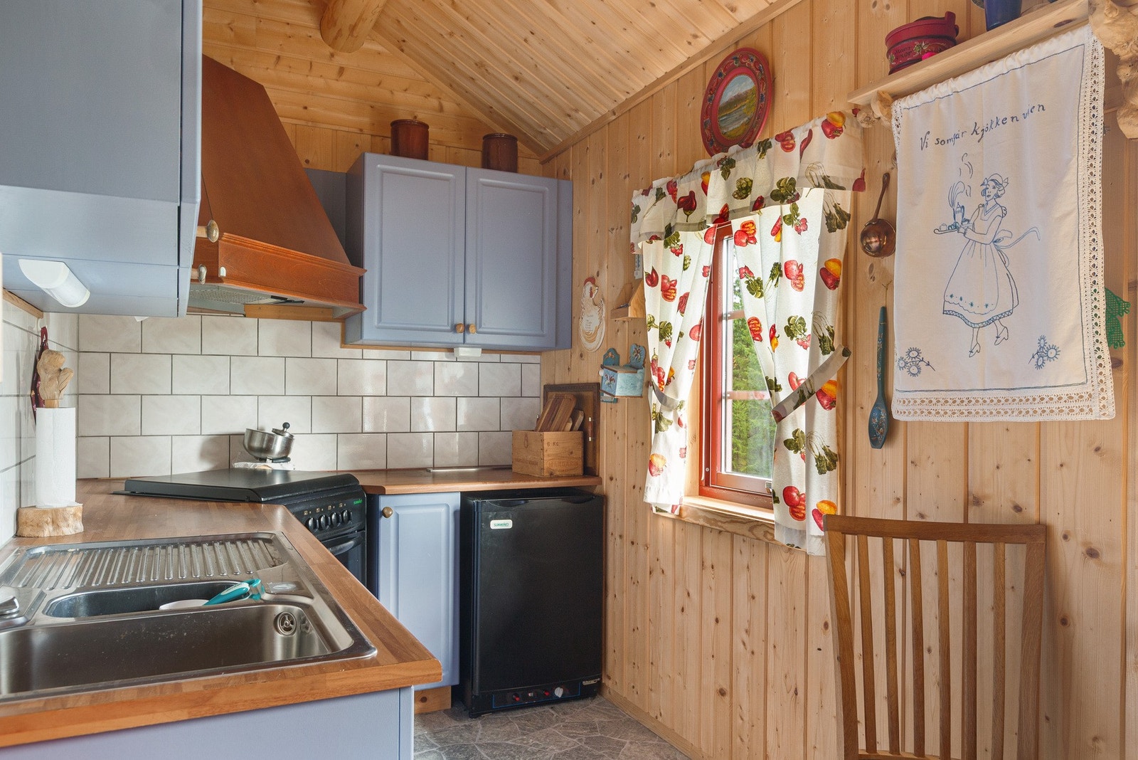 Profilerte fronter. Laminert benkeplate. Flis over benkeplate. Belysning over benkeplate. Dobbel kjøkkenkum. Kjøkkenvifte med avtrekk ut. Komfyr, gass. Kjøleskap, gass. Galleribilde