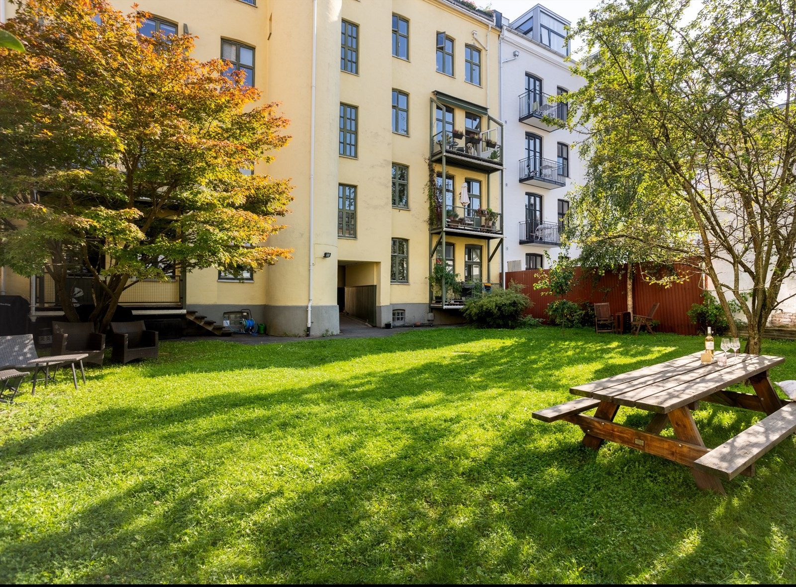 Felles bakgårdshage er pent opparbeidet med plen og trær Galleribilde