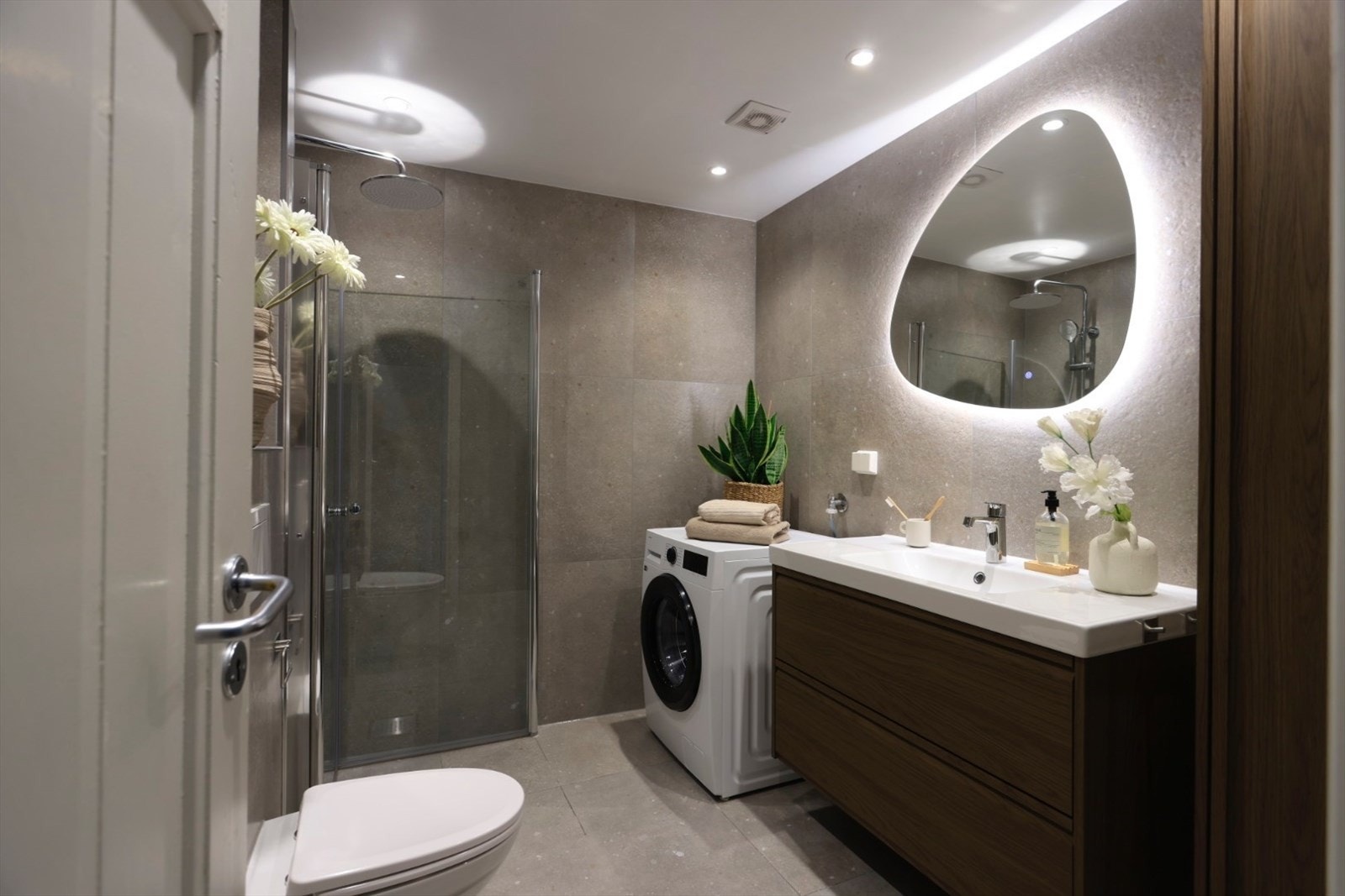 Delikat bad med opplegg til vaskemaskin og godt med lagringsplass i skuffer og skap Galleribilde