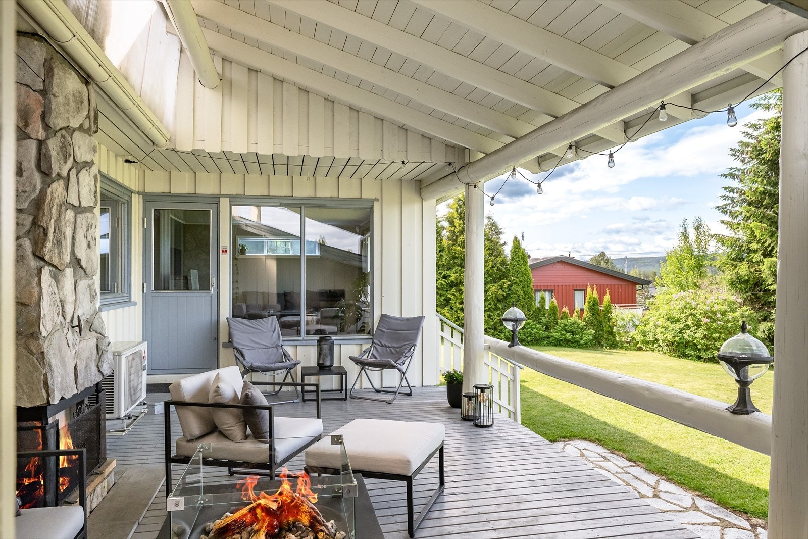 Terrassen er overbygget, har terrassebord på gulv og en flott åpen peis med naturstein. Galleribilde