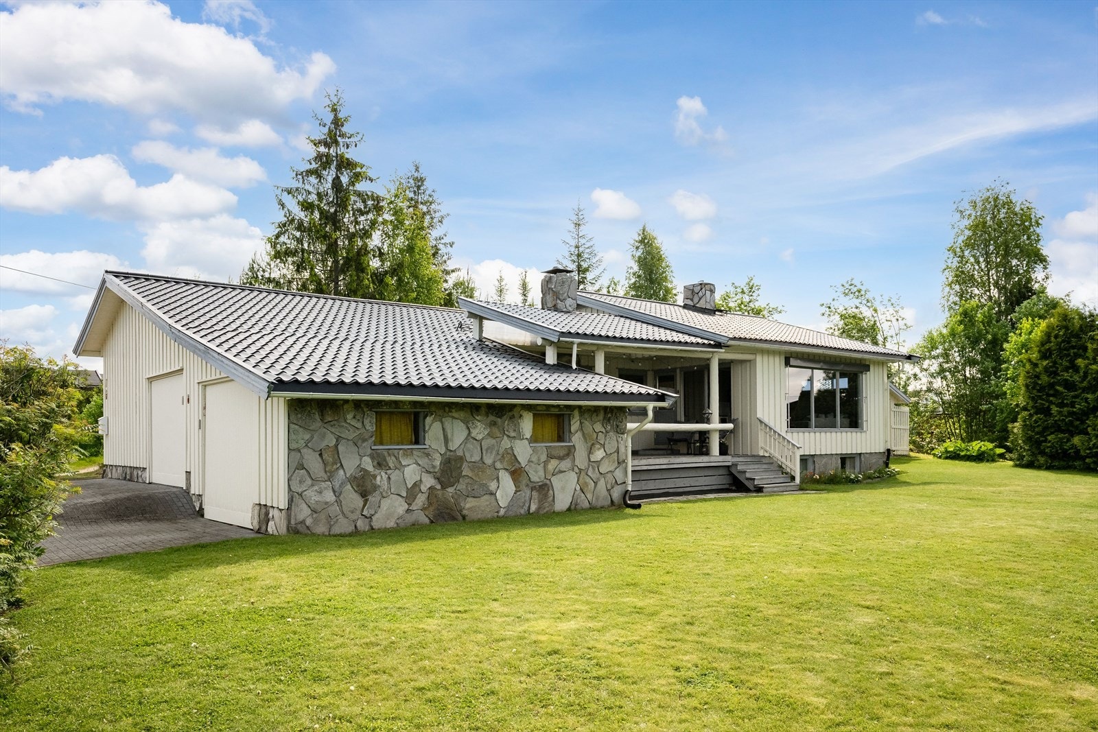 En velholdt og fin enebolig med yttervegger av stående tømmermanskledning og naturstein. Galleribilde