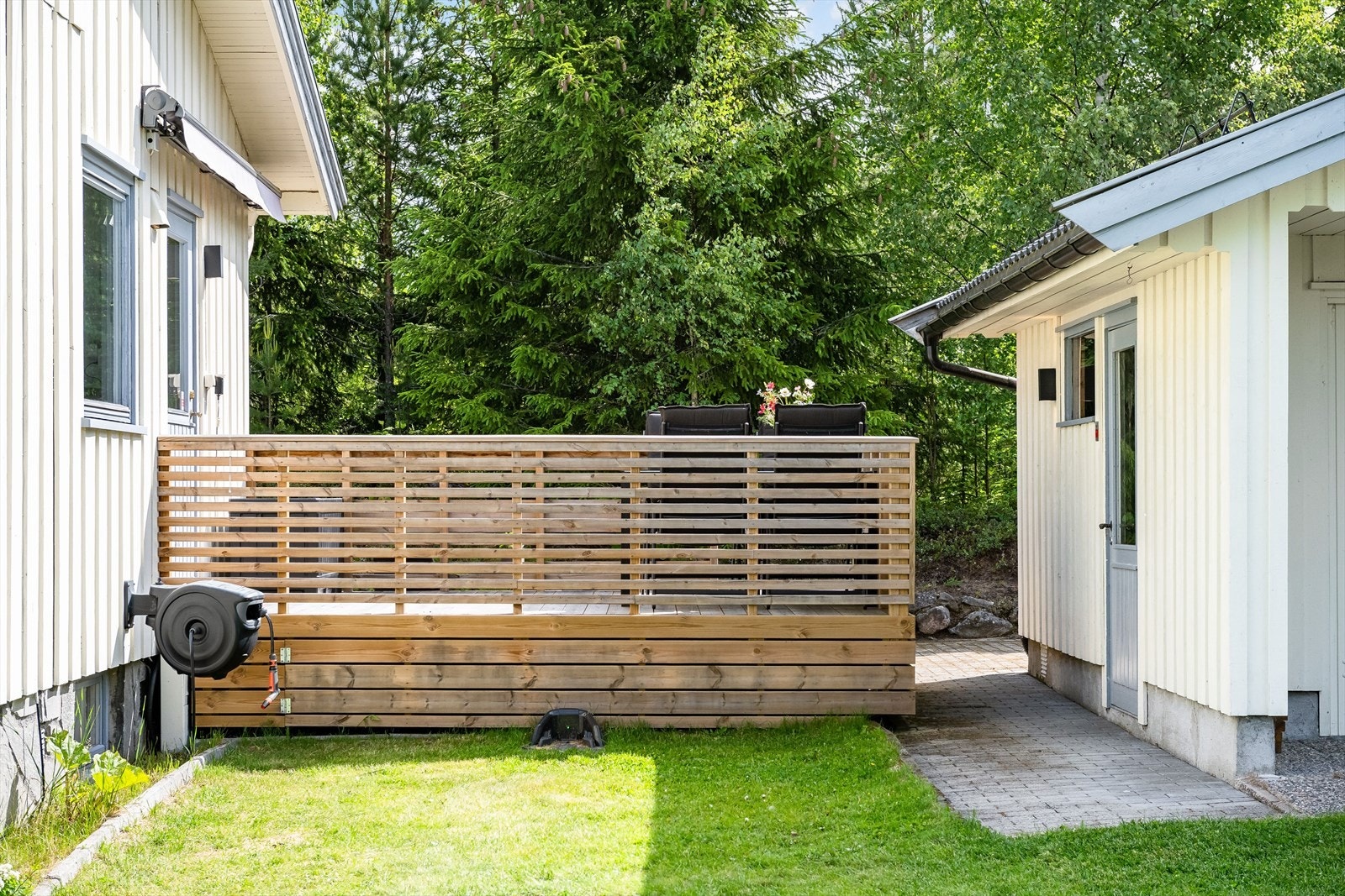 Terrassen har terrassebord på gulv, rekkverk med liggende trespiler og god plass til sittegruppe. Det er også montert markise, utebelysning og stikkontakt. Galleribilde