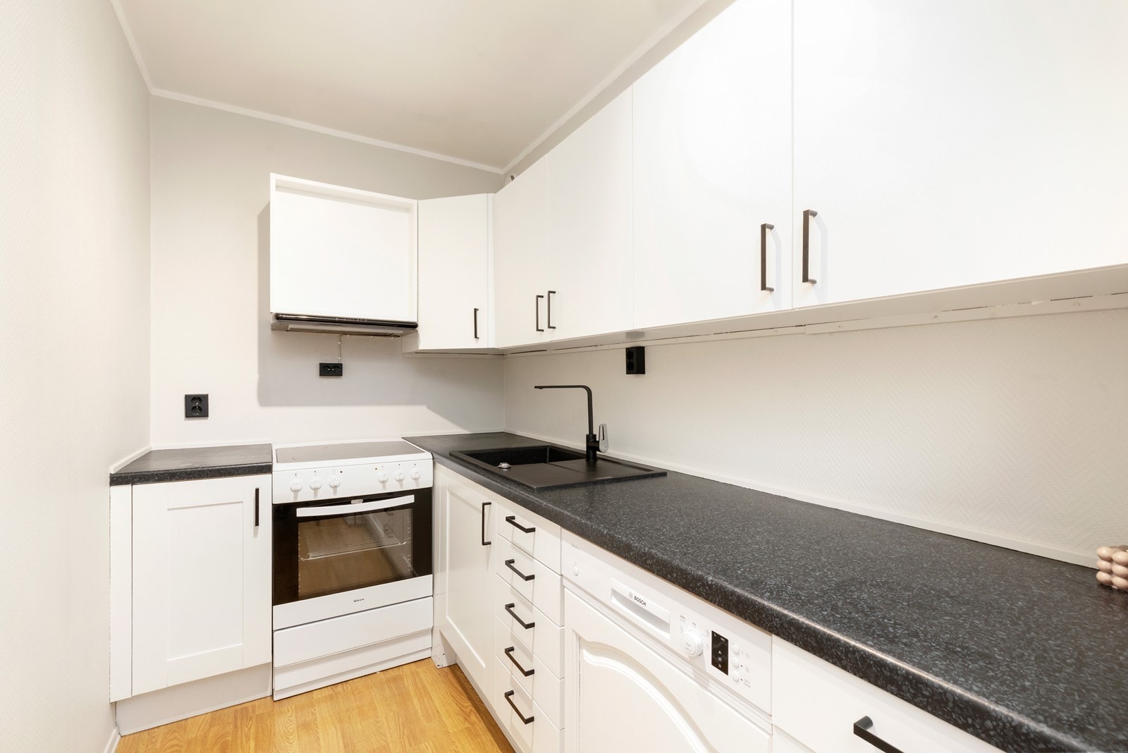 Kjøkken med hvite profilerte fronter og laminat benkeplate. Galleribilde