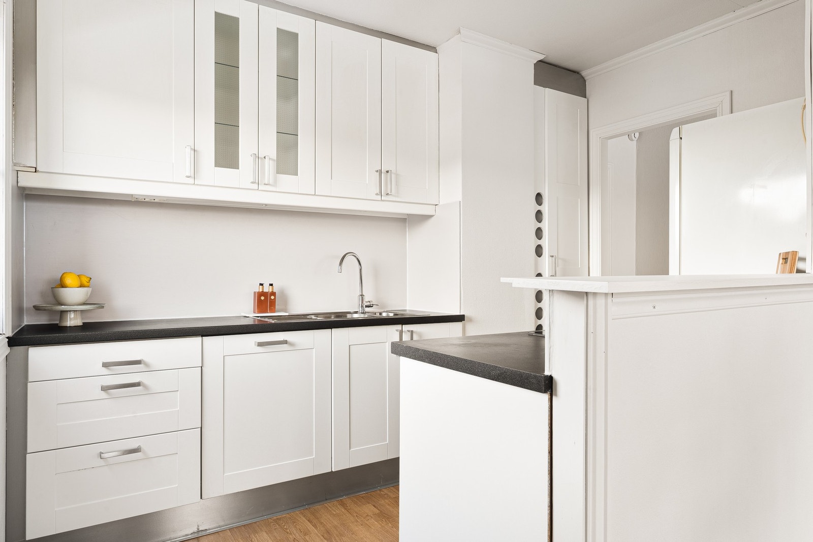 Kjøkken med profilerte fronter og laminat benkeplate med nedfelt vask av stål. Galleribilde