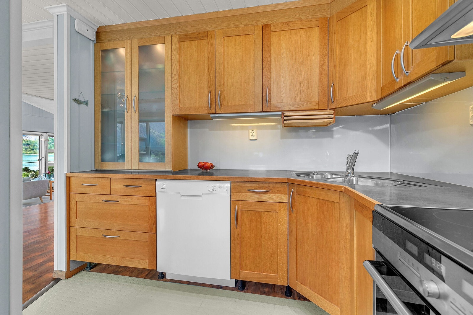 Kjøkkenet har rikelig med lagringsplass og takhøye skap Galleribilde