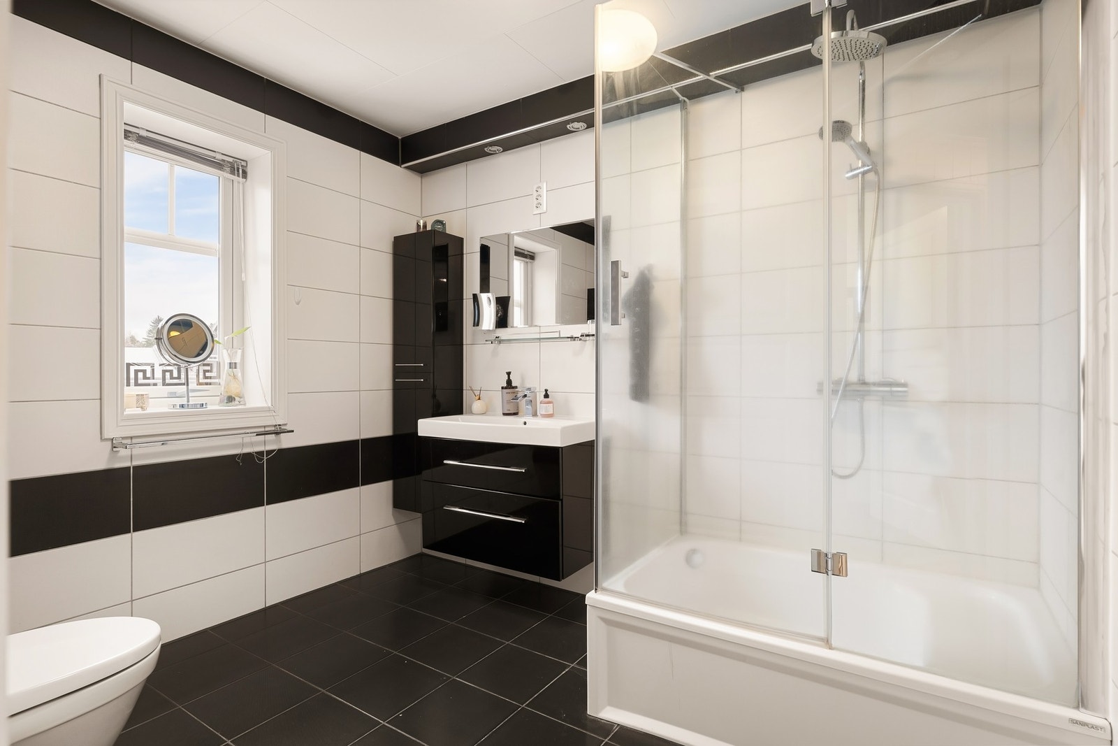 Dusjkabinett med foldedører og servant på skap Galleribilde