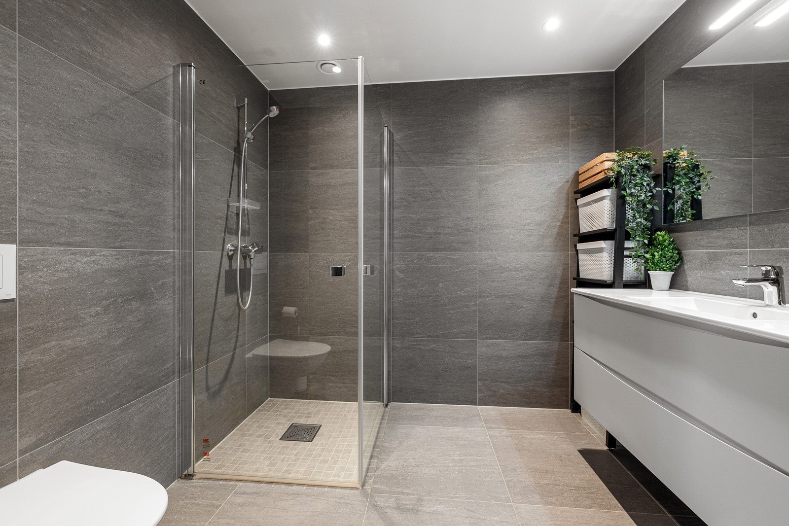 Pent flislagt bad med gulvvarme og downlights i himlinger. Galleribilde