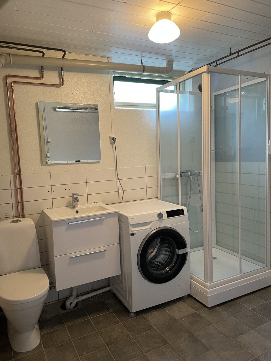 Bad i kjeller med helt ny vaskemaskin, servant, toalett og dusjkabinett Galleribilde
