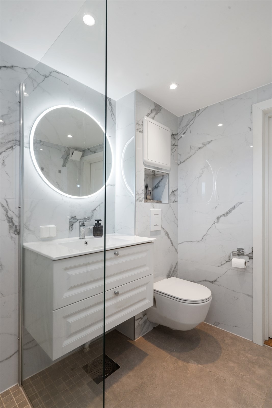 Stilfull baderomsinnredning med vegghengt toalett -og servant. På badet er det varmekabler. Galleribilde