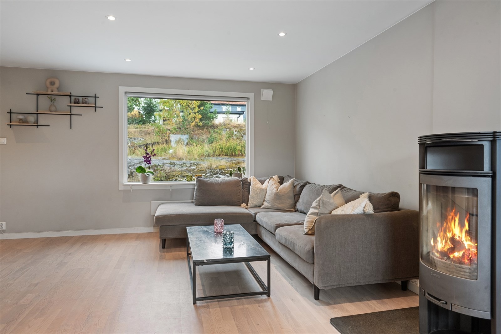 Store vindusflater gir rom for både dagslys og utsikt til uteområdet fra stuen. Galleribilde