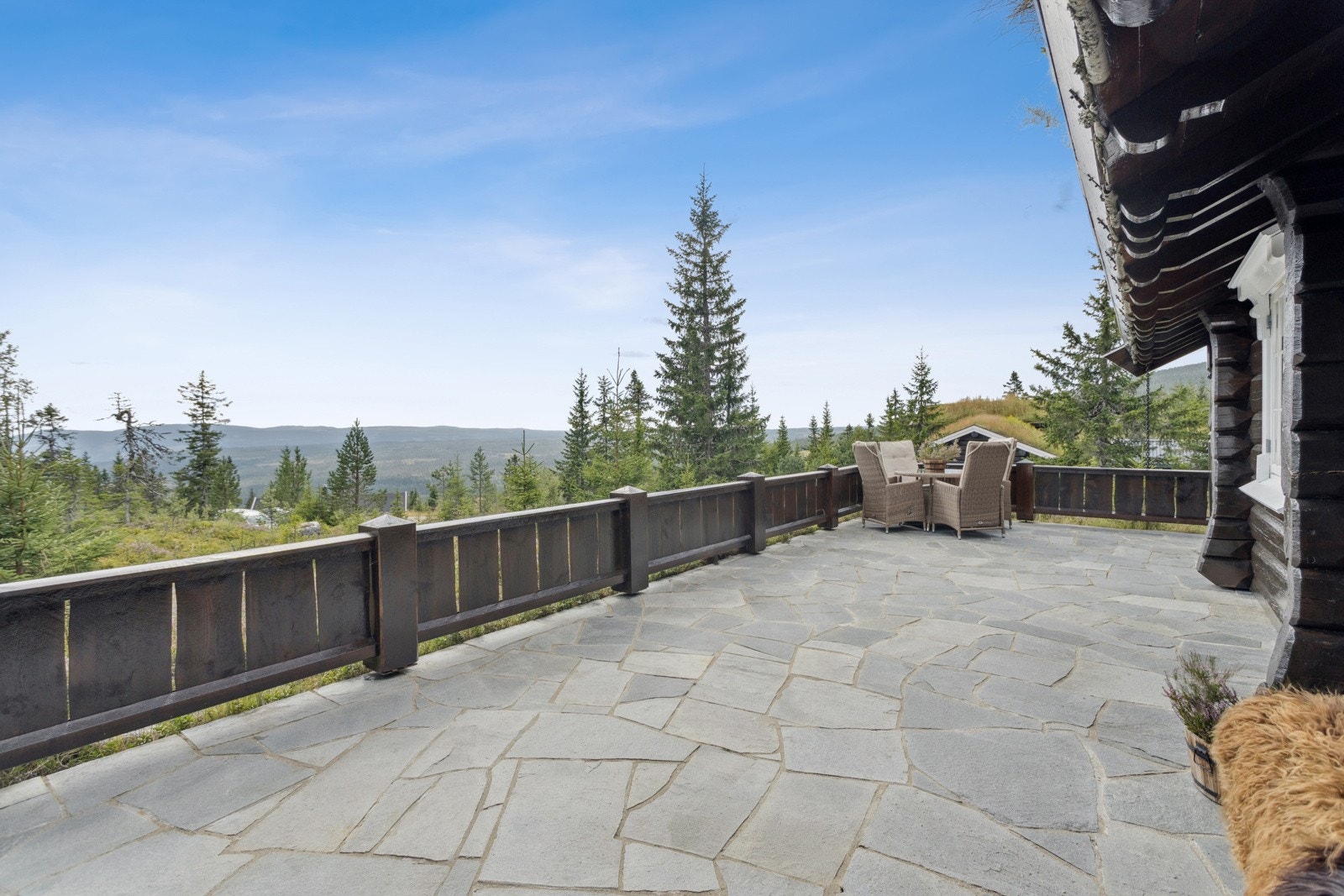 I front av hytta og mot inngangsparti er det en romslig terrasse - merk også at denne er utført med lekkert skifergulv. Galleribilde