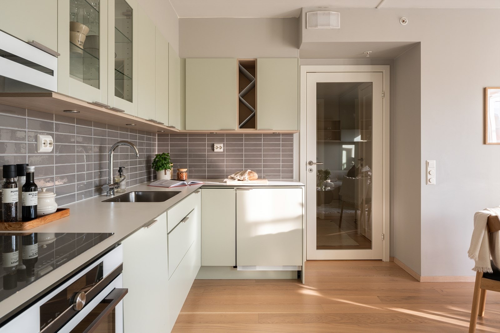 Integrerte hvitevarer, laminert benkeplate og fliser mellom over- og underskap. Galleribilde