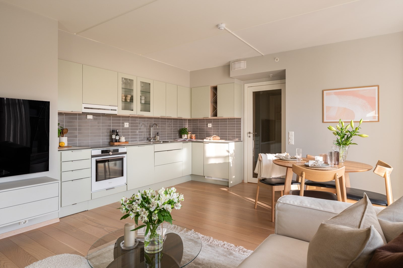 Kjøkken og stue i åpen og sosial løsning med plass til både sofaseksjon og spisebord. Galleribilde