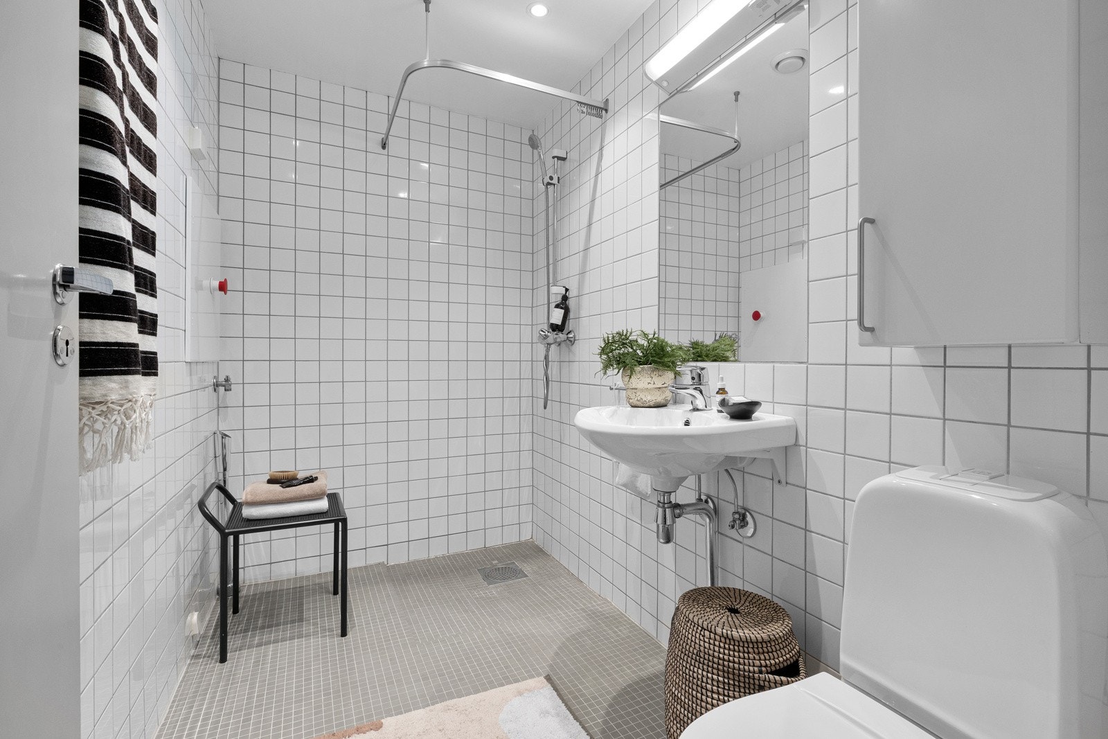 Dusjhjørne med ettgreps dusjbatteri, gulvstående toalett, opplegg for vaskemaskin og servant med ettgreps blandebatteri Galleribilde