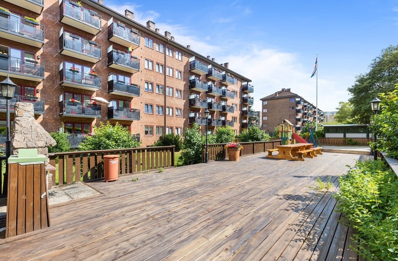 Stor platting med grill og flere sittegrupper. Galleribilde