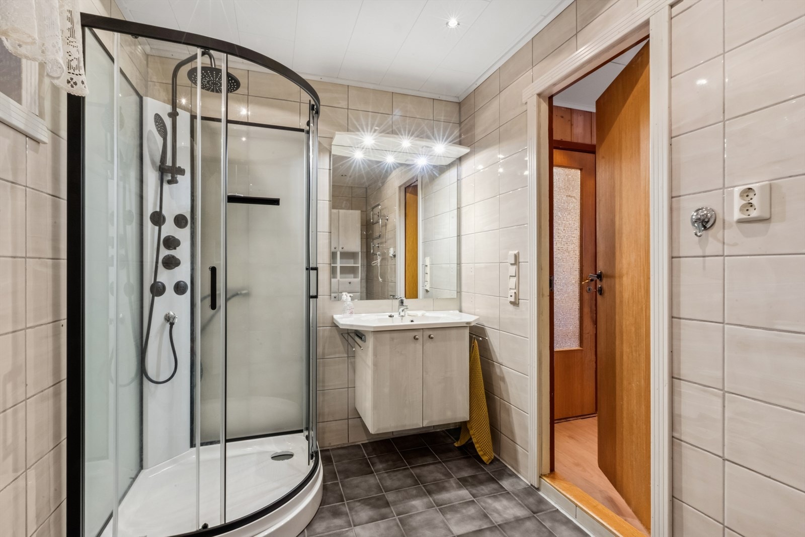 Badet ligger i hovedetasjen og er utstyrt med servant med underskap. speil med spott belysning. Nytt dusjkabinett og gulvmontert toalett fra 2025. Galleribilde