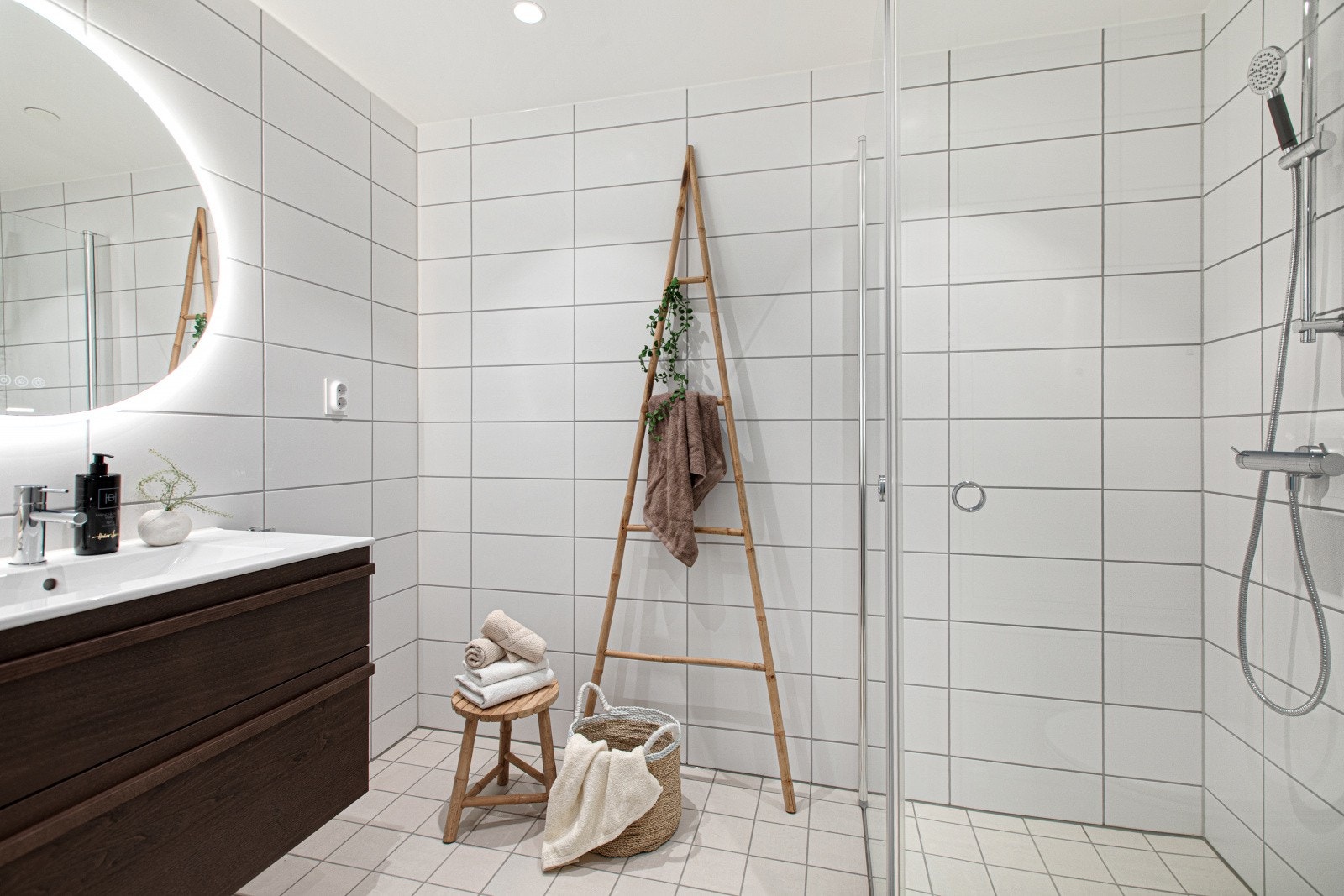 Baderommet er utført i et tidløst design og har baderomsinnredning med skuffeseksjon, speil med tilhørende belysning, vegghengt toalett og dusjnisje med innfellbare glassdører. Galleribilde