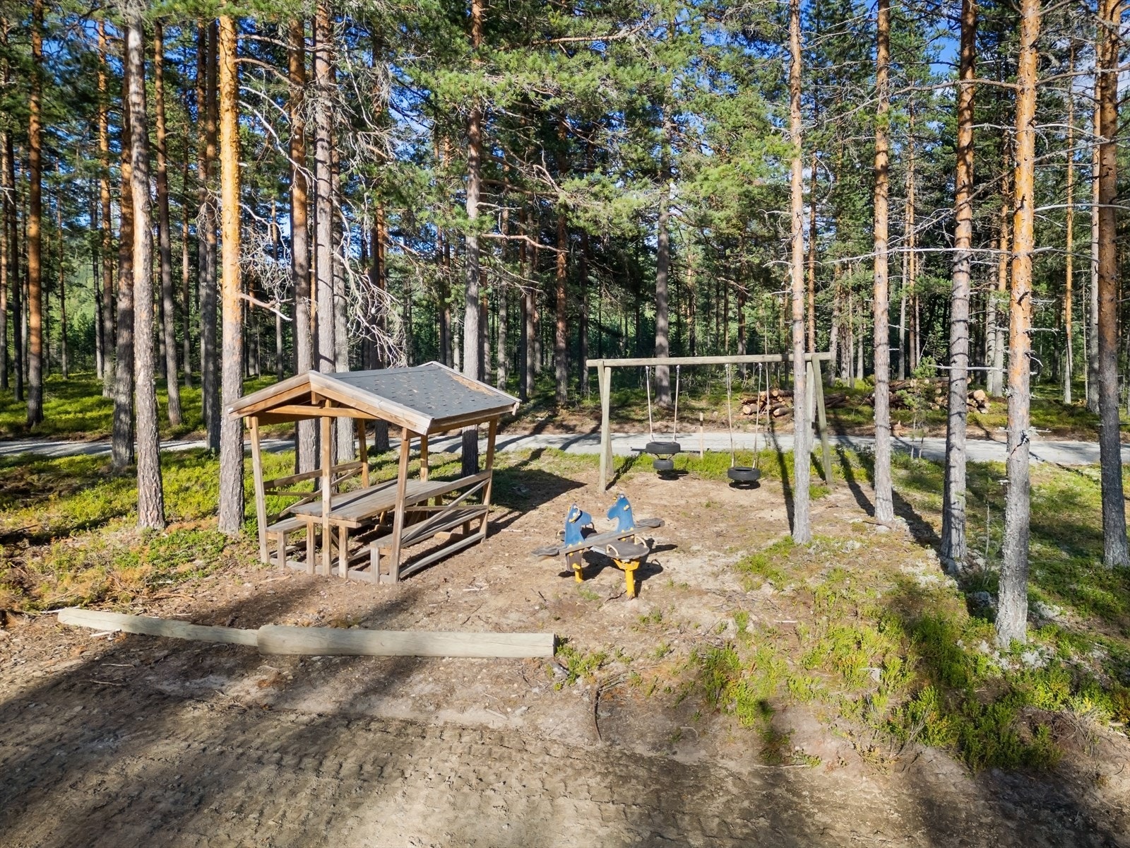 En hyggelig lekeplass i nærheten med huskestativ, der barna kan leke fritt. Galleribilde