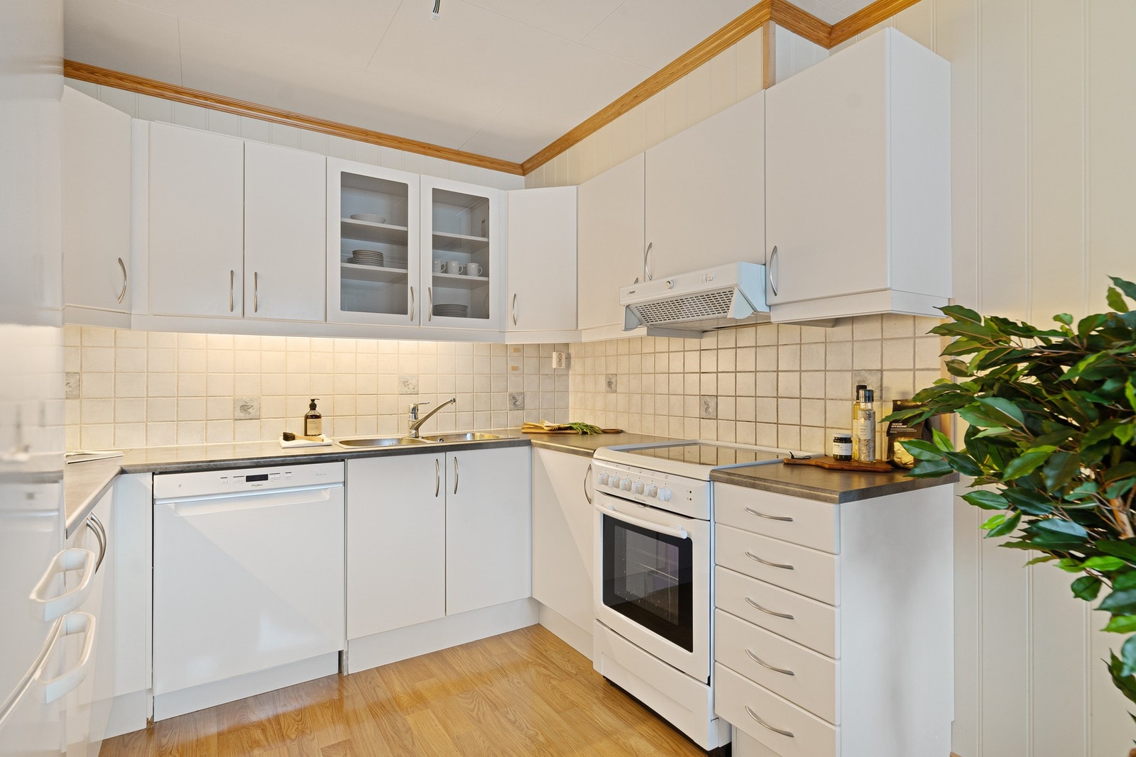 Innredningen har glatte fronter og laminat benkeplate, og kjøkkenet er utstyrt med nødvendige hvitevarer som kjøl/frys, oppvaskmaskin og komfyr. Dette er et kjøkken som fungerer godt både til daglig bruk og når man har gjester. Galleribilde