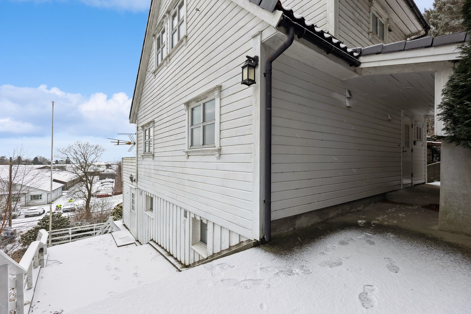 Det er en uteplass med betongdekke ved siden av huset, som gir tilgang til flere innganger. Galleribilde