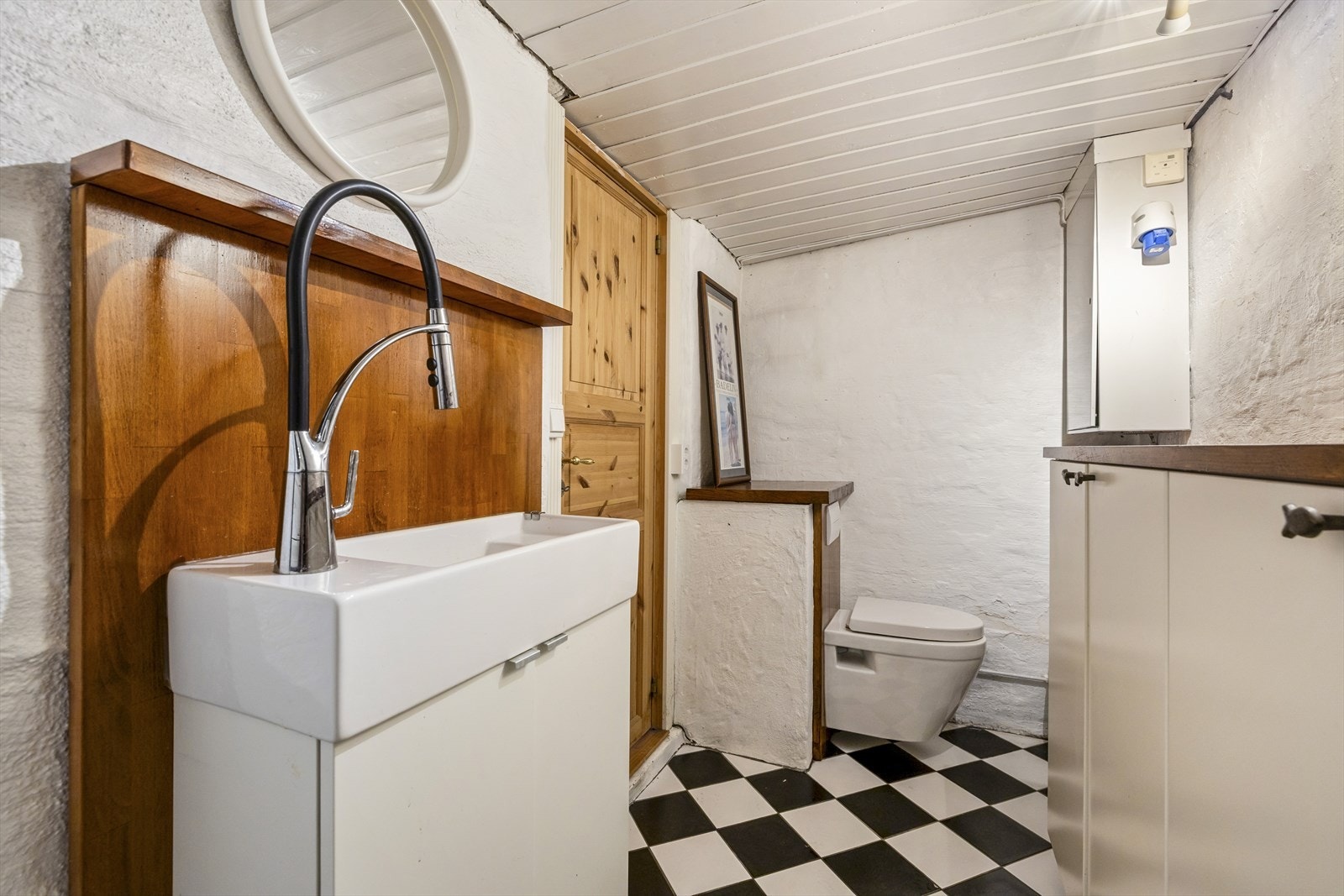 Vaskerommet i underetasjen er utstyrt med enkel servantinnredning, veggmontert toalett og skap for ekstra oppbevaring. Galleribilde