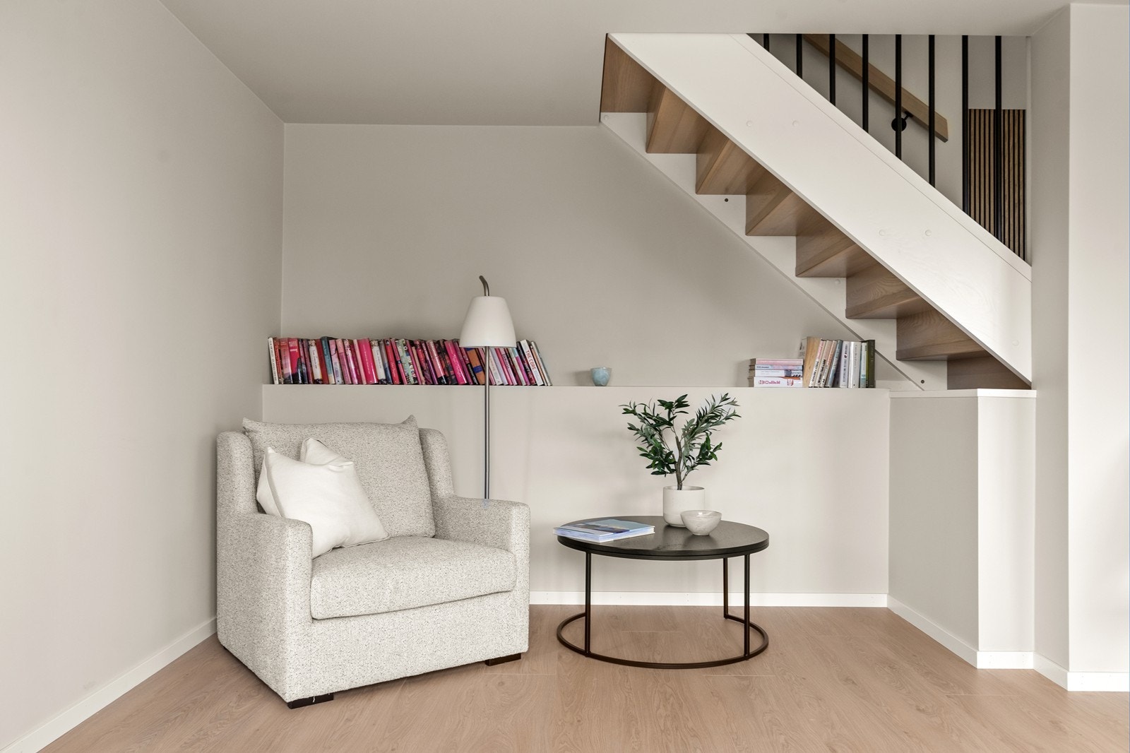 En koselig plass under trappa - med en praktisk hylle som kan brukes som bokhylle Galleribilde