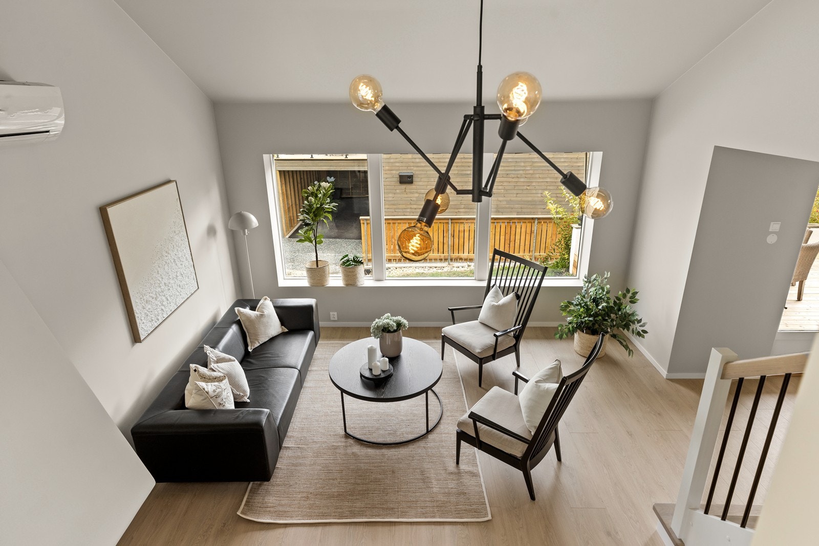 I dagligstua er det flere store vindusflater som slipper inn godt med dagslys, og den høye skråhimlingen gir et ekstra luftig preg på rommet Galleribilde