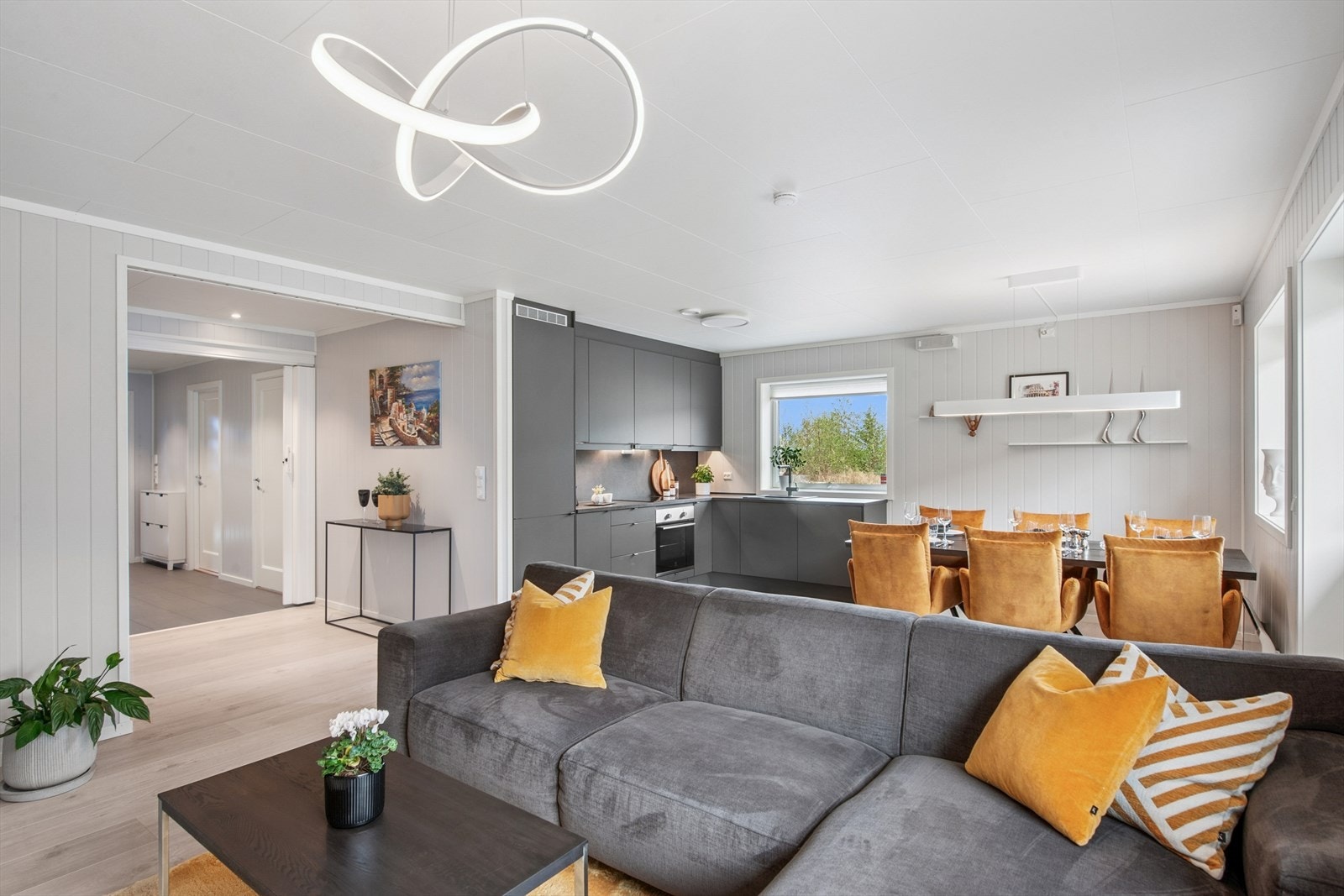 Store vindusflater og gjennomgående lyse og moderne laminatgulv skaper en helhetlig og luftig atmosfære. Galleribilde