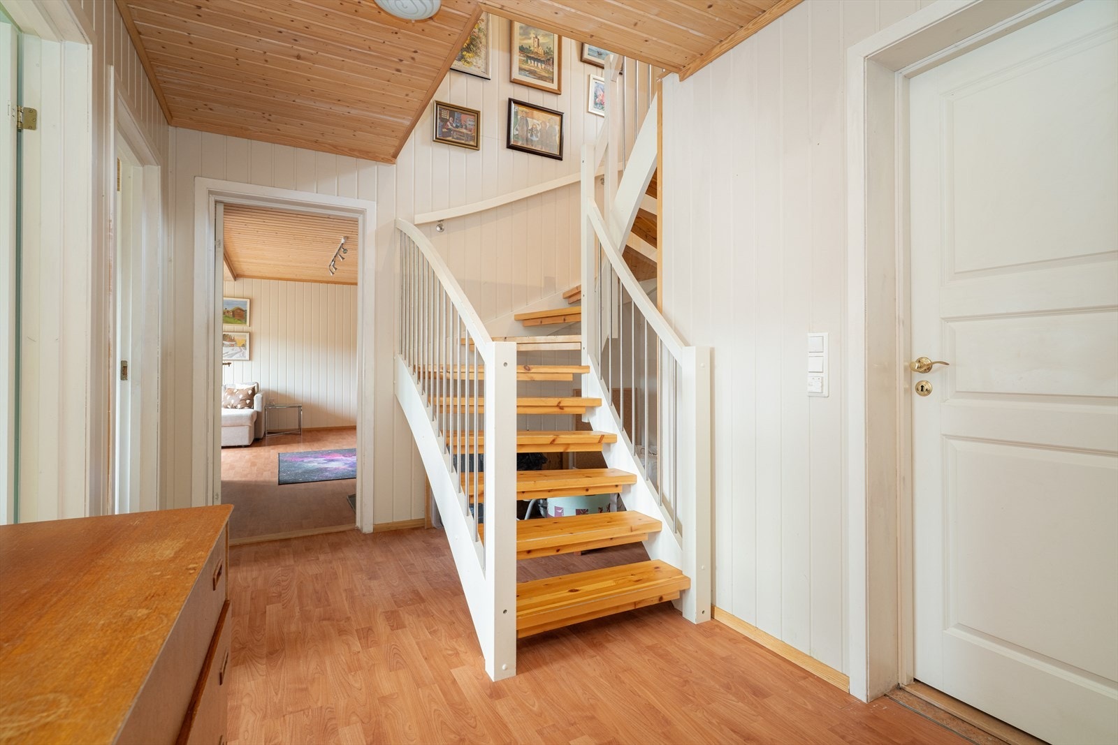 Malt tretrapp mellom etasjene, med åpne opptrinn. I sokkeletasjen er det montert ny varmepumpe av Telemark Energispar i 2020/21. Galleribilde