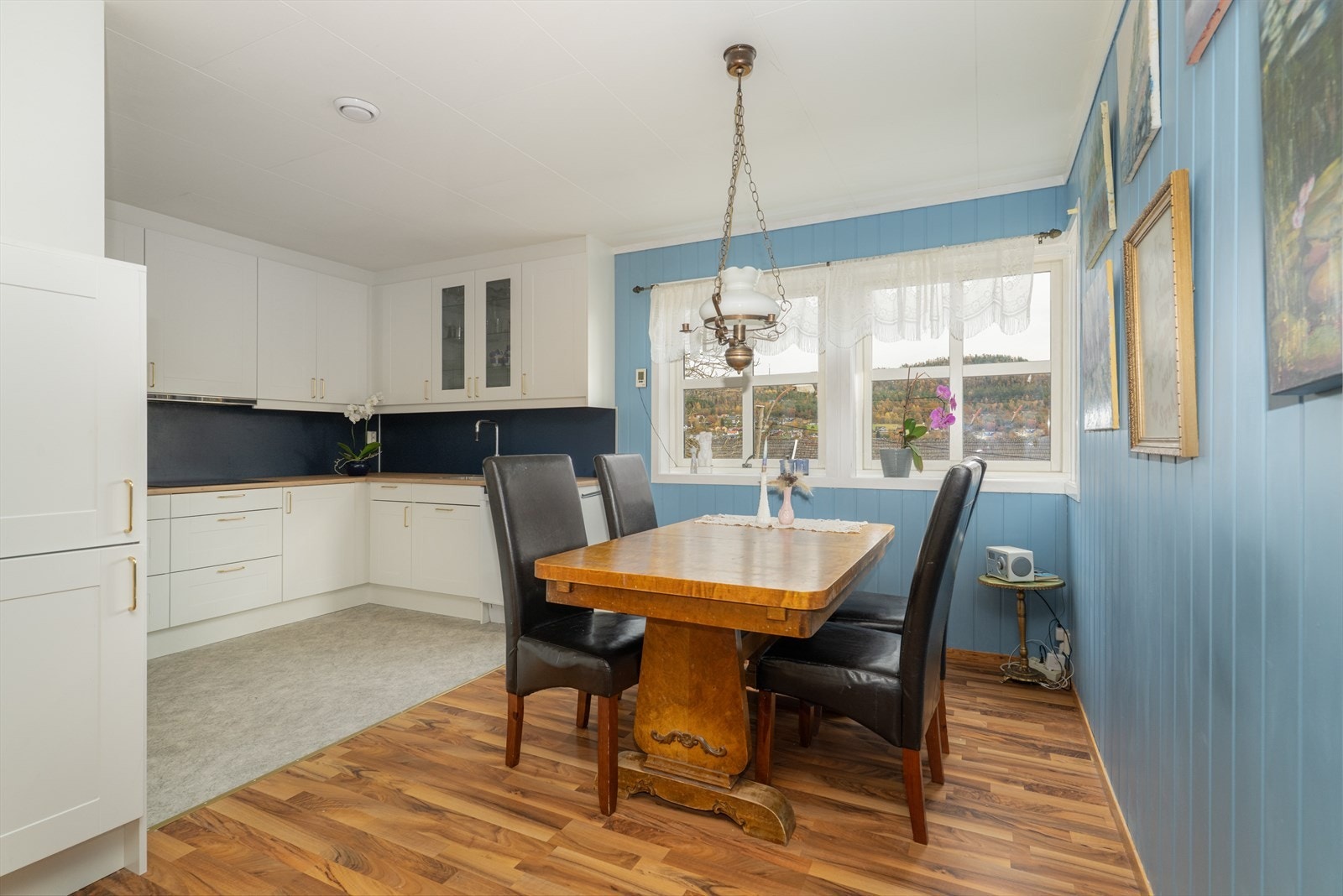 Pent kjøkken i delvis åpen løsning, med fin spiseplass og lys, takhøy kjøkkeninnredning type Systemkjøkken fra 2024. Galleribilde