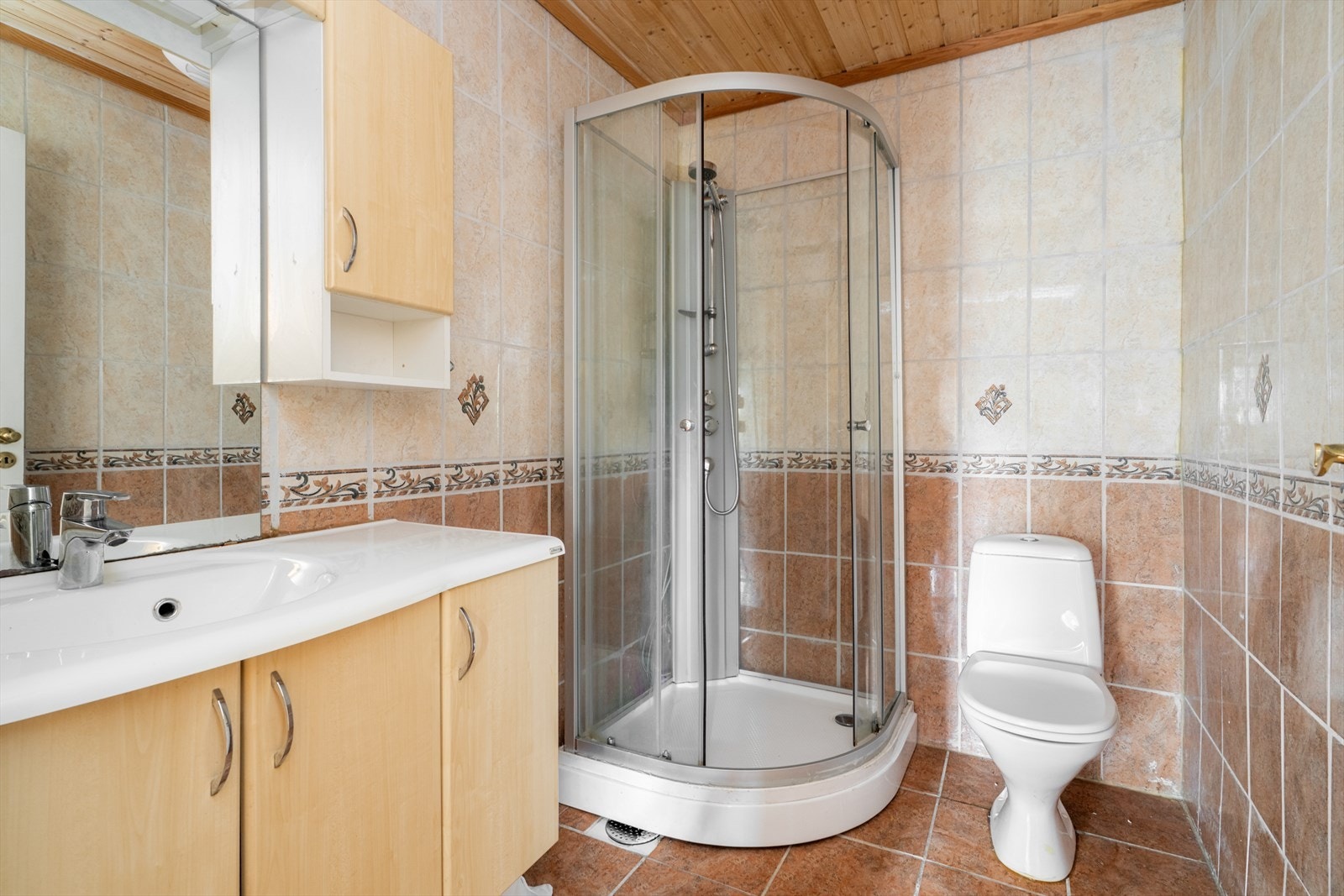 Flislagt bad i sokkeletasjen, med standard fra byggeår. Badet har varmekabler i gulv, toalett og dusjkabinett, samt servantinnredning. Galleribilde