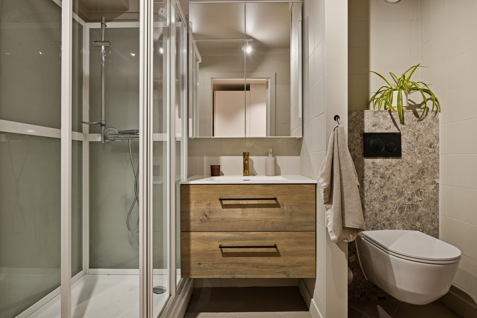 Av utstyr har du vegghengt Wc, servant med underskap, speilskap og dusjkabinett. Galleribilde