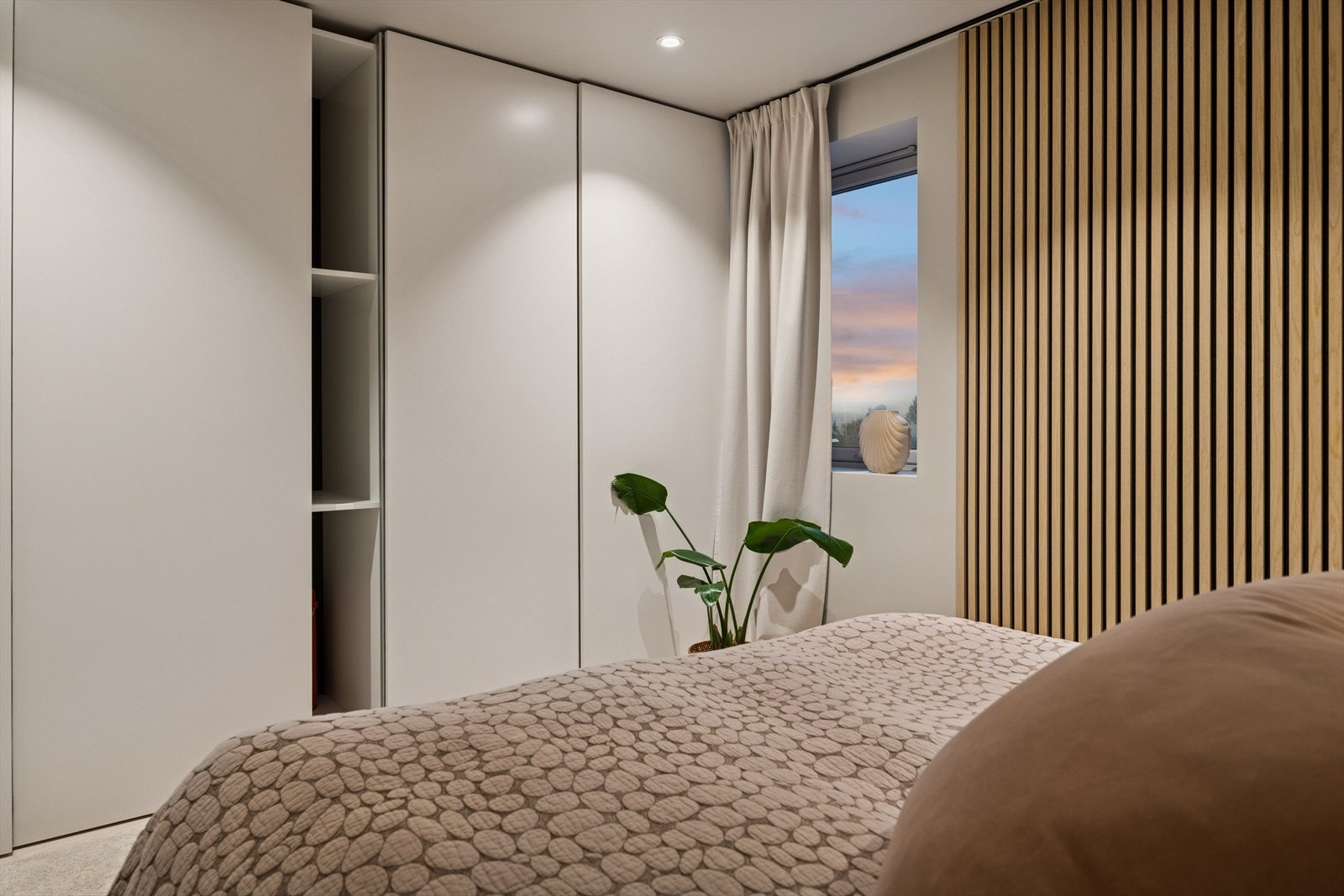 Romslig soverom med gjennomtenkt garderobeløsning med lys, praktisk og elegant for optimal oppbevaring. Galleribilde