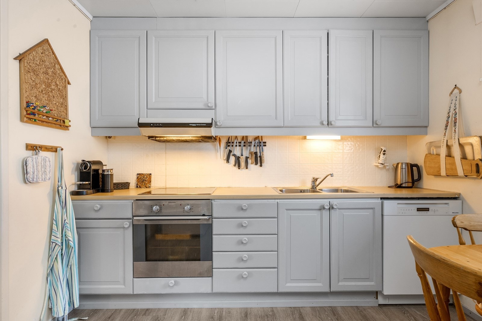 Kjøkkenet har malte fronter, laminatbenkeplate og opplegg for oppvaskmaskin - over benk er det lagt fliser. Galleribilde