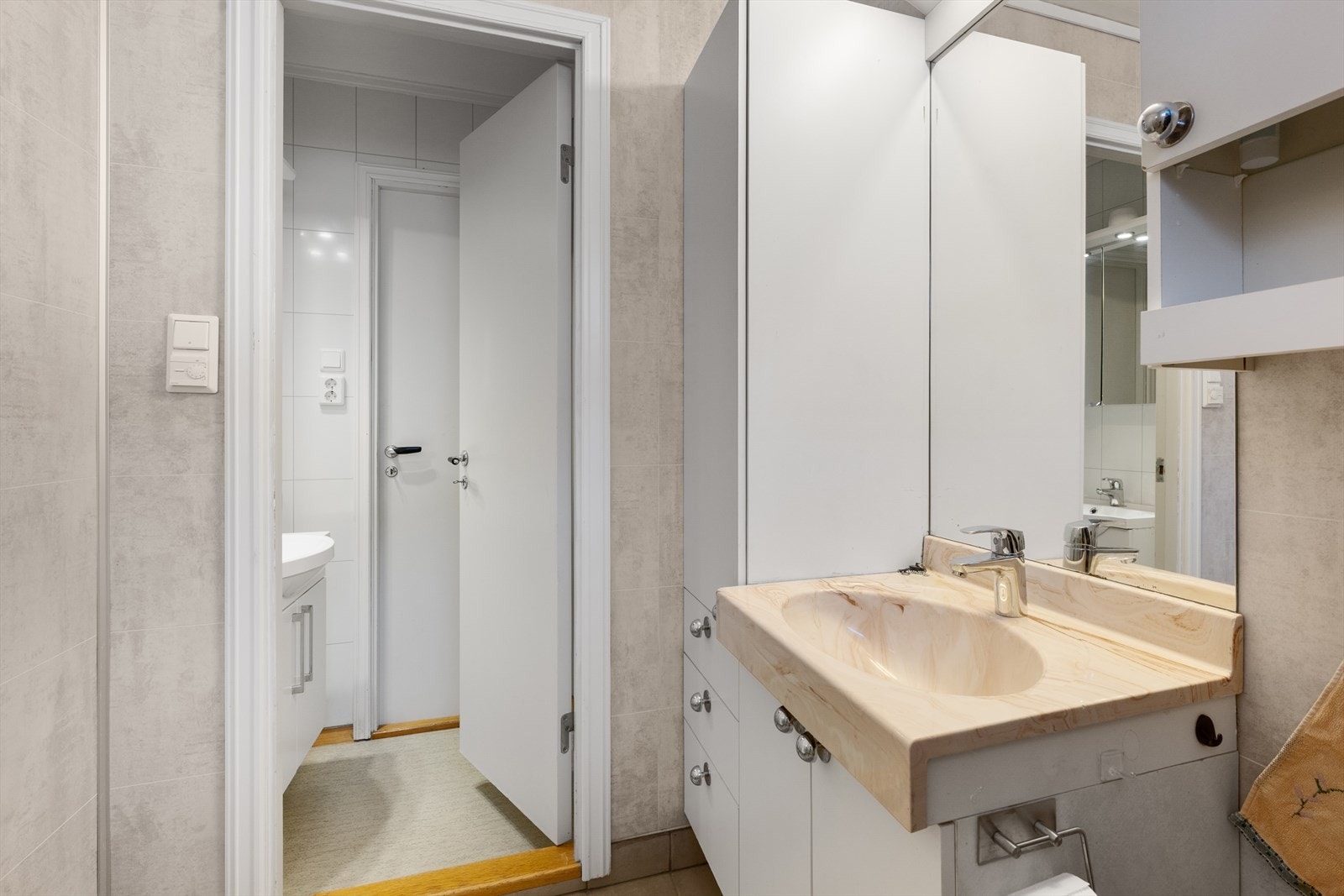 Badet på hovedplanet har våtromsplater på vegg og flislagt gulv med varmekabler, og et forrom med innredning og servant. Galleribilde