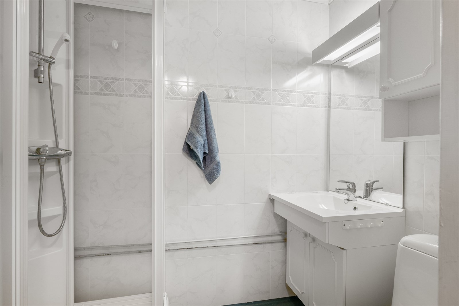 Badet i underetasjen har våtromsplater og gulvbelegg og er utstyrt med WC, servant og dusjkabinett. Galleribilde