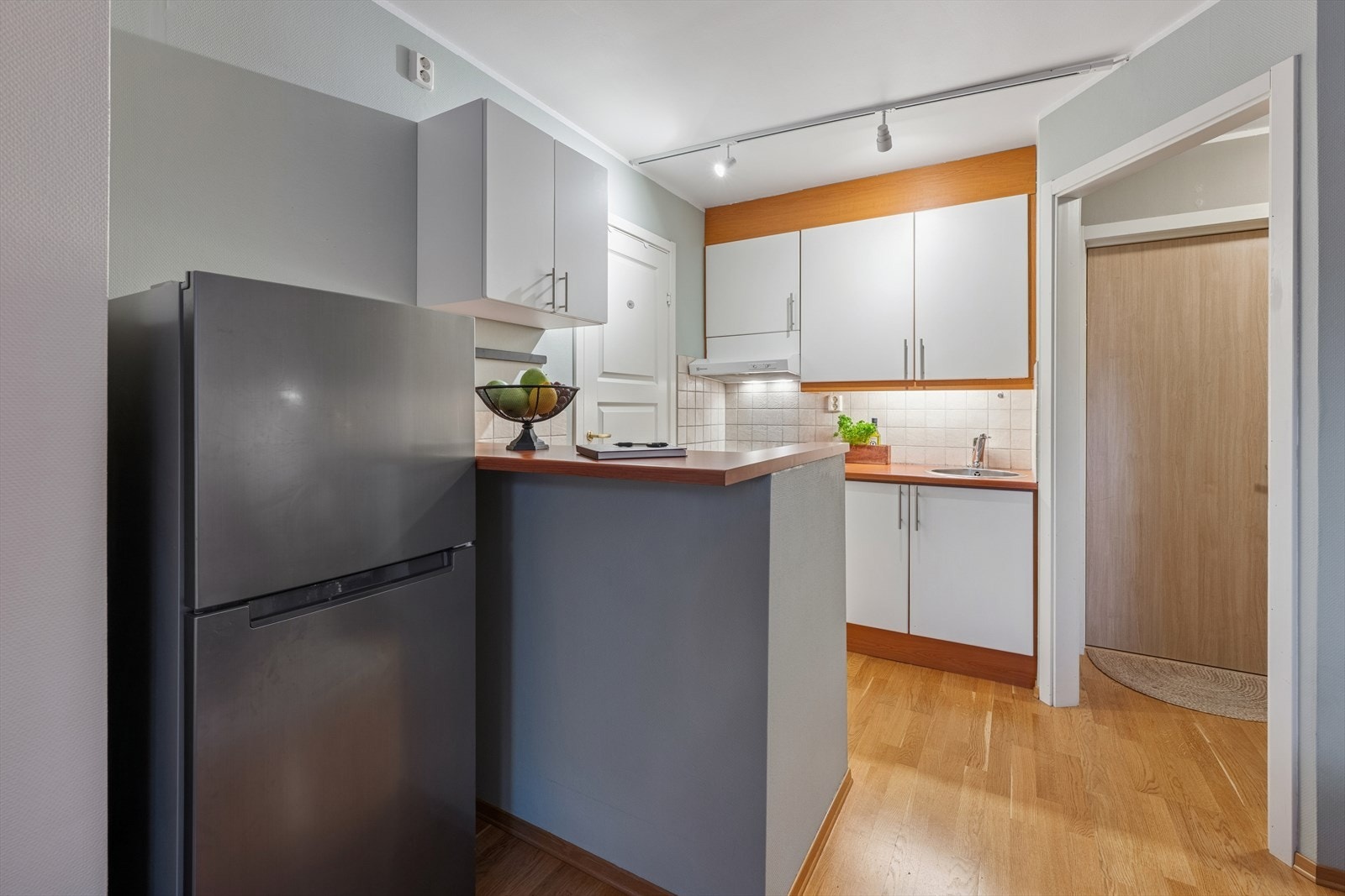 Tidløst kjøkken med hvite slette fronter og benkeplate av typen laminat. Galleribilde