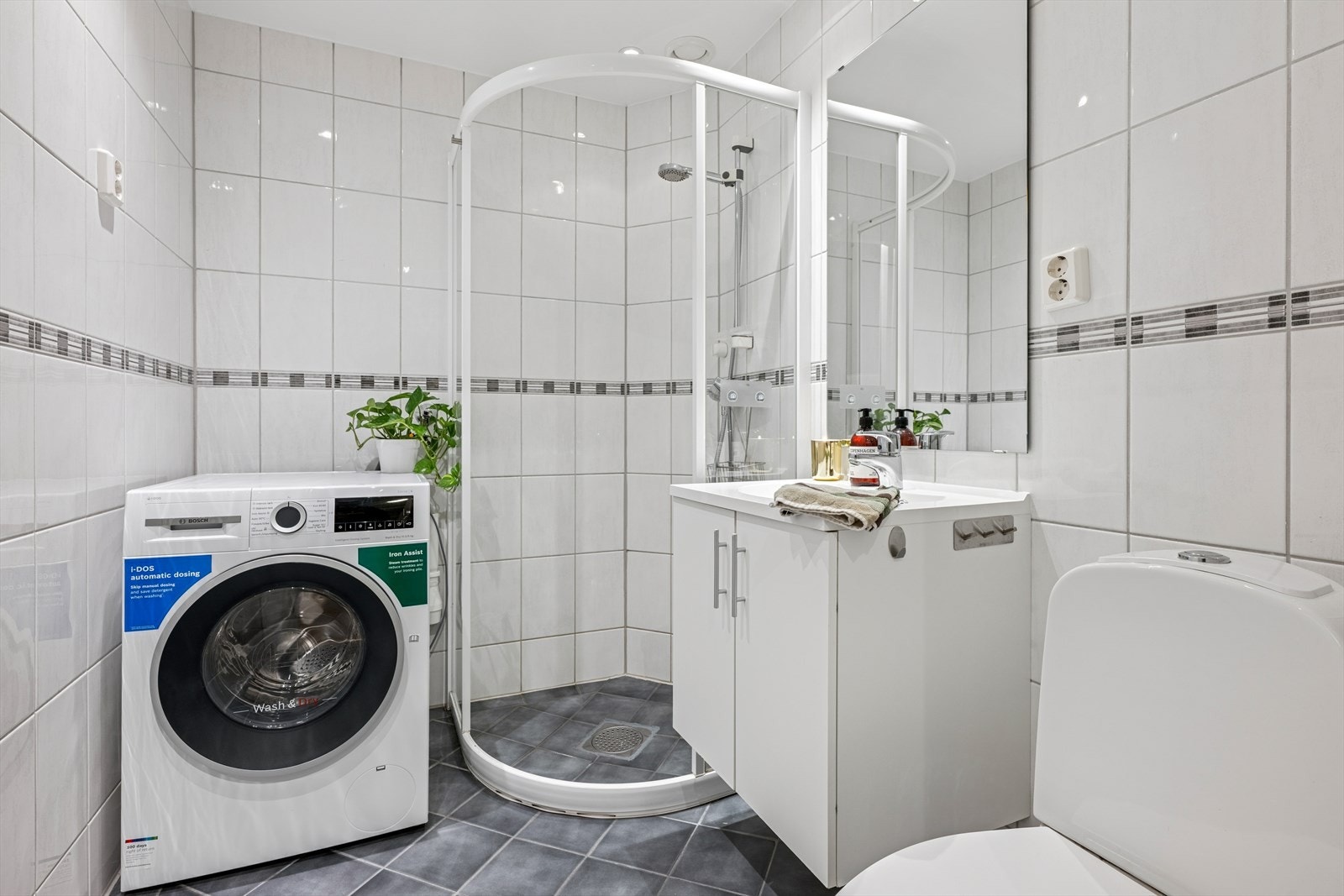 Badet er utstyrt med dusjhjørne, toalett og opplegg for vaskemaskin. Galleribilde