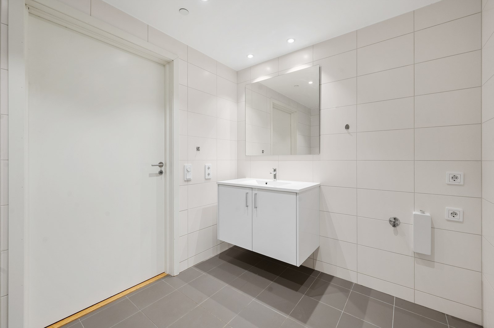 Bad med toalett, dusjhjørne, servant og opplegg for vaskemaskin. Galleribilde