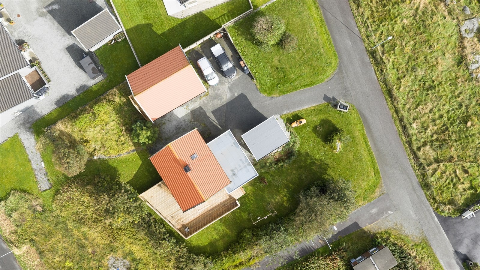 Eiendommen har en romslig tomt med plen og beplantning som gir et grønt og trivelig preg Galleribilde