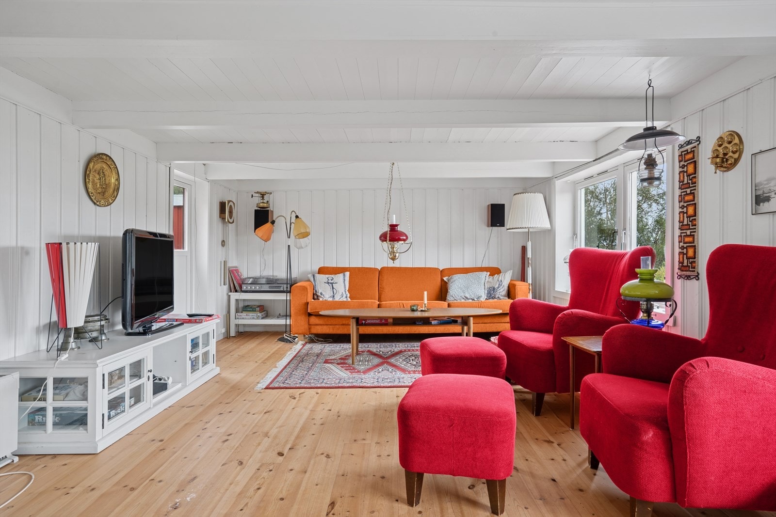 Stor stue med hvitmalte veggflater og mye innlys. Galleribilde