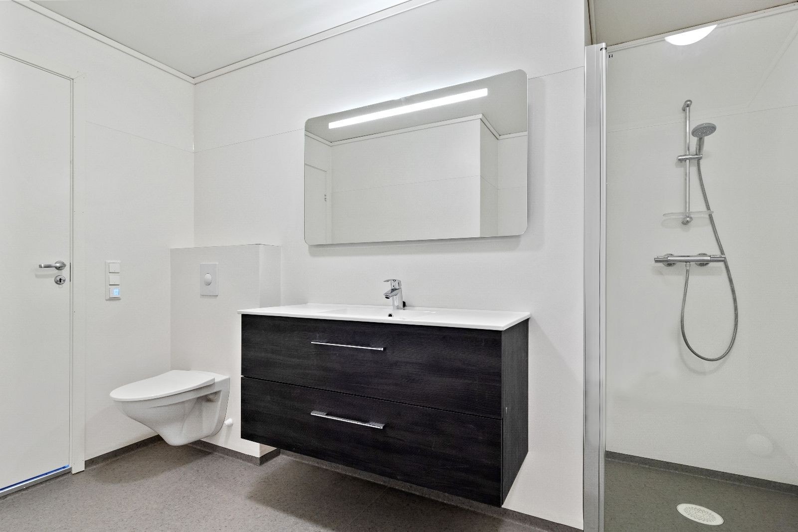 Fint bad med dusjhjørne, vegghengt baderomsmøbel og toalett. Varme i gulv. Galleribilde