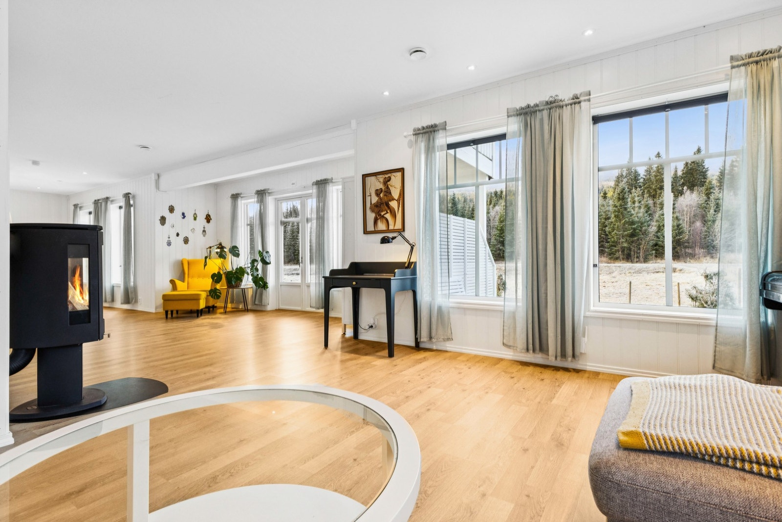 Romslig og lys stue med store vindusflater som gir en lun og hyggelig atmosfære. Galleribilde