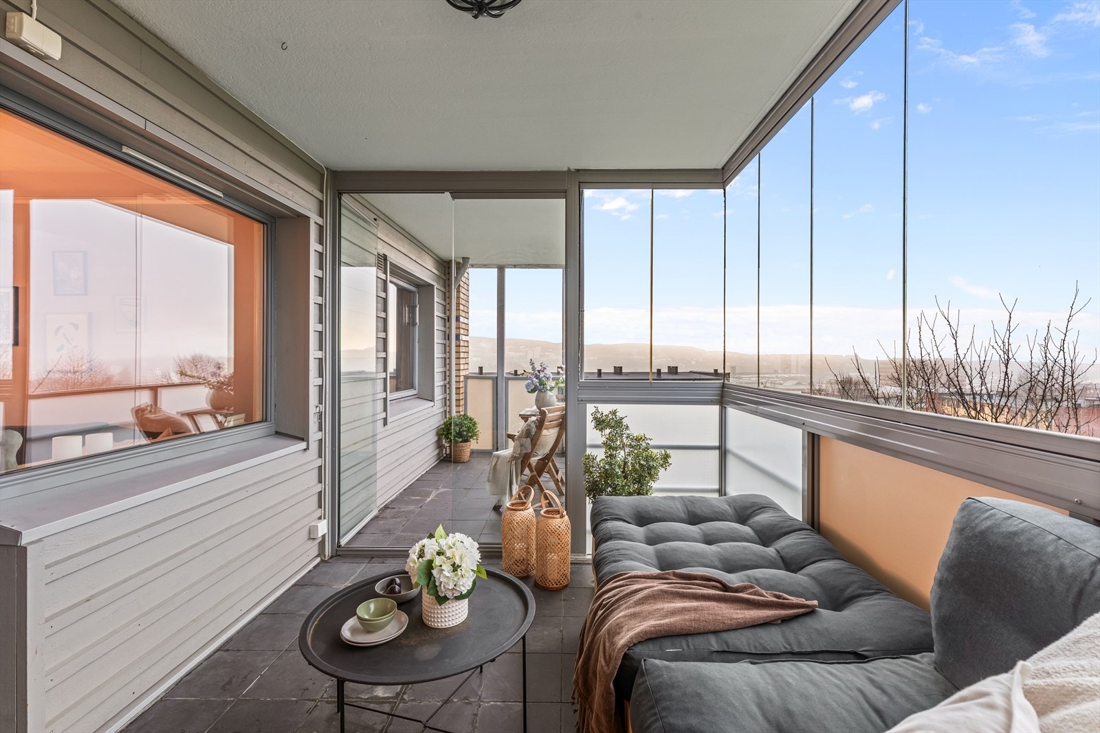 I den innglassede balkongen er det godt og lunt, perfekt for en komfortabel sittegruppe hvor du kan nyte livet og hyggelige kvelder langt utover dagen. Galleribilde