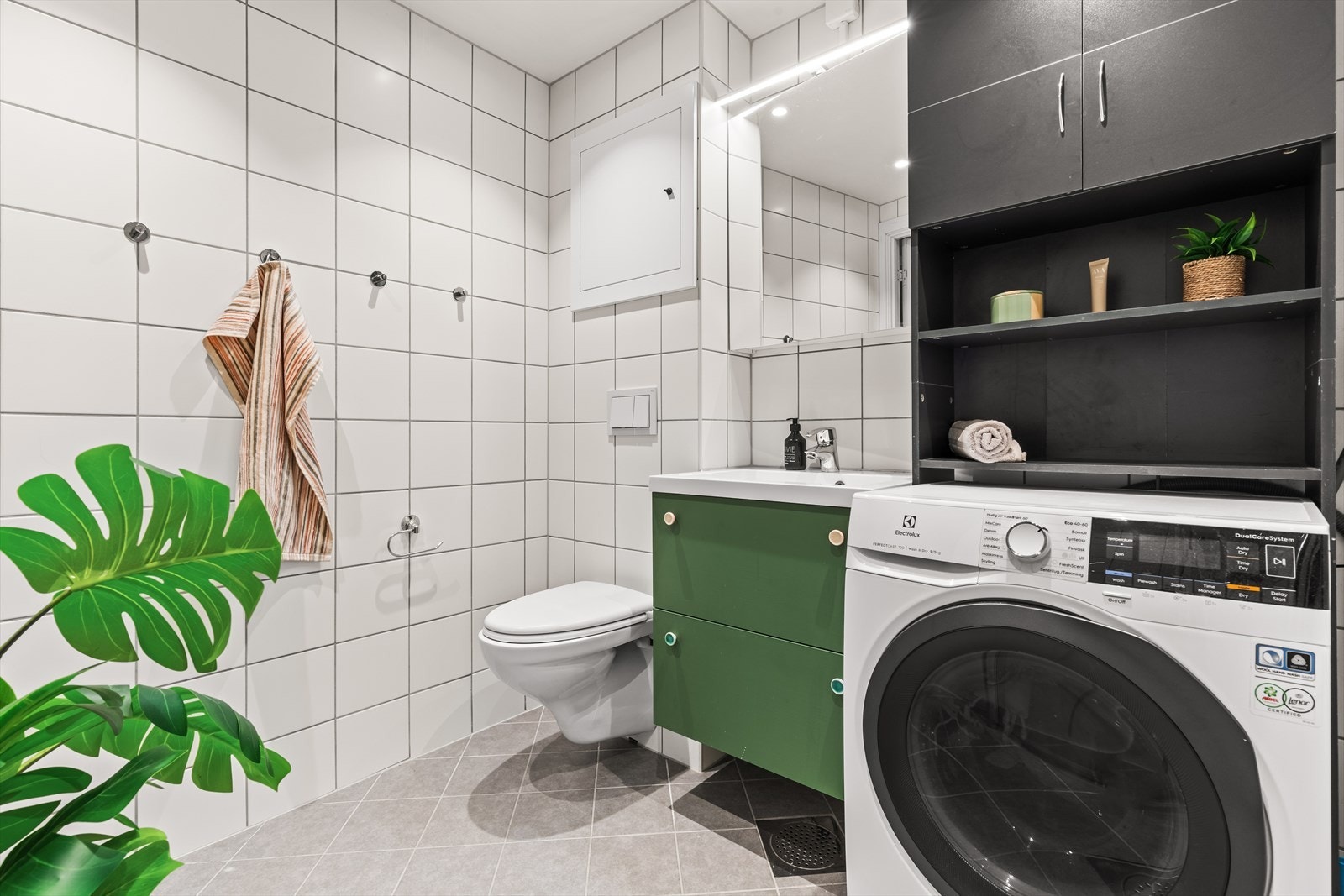 Badet er praktisk utformet med rikelig oppbevaringsplass i servantskapet, samt ekstra oppbevaring over vaskemaskinen. Det er også opplegg for vaskemaskin. Galleribilde