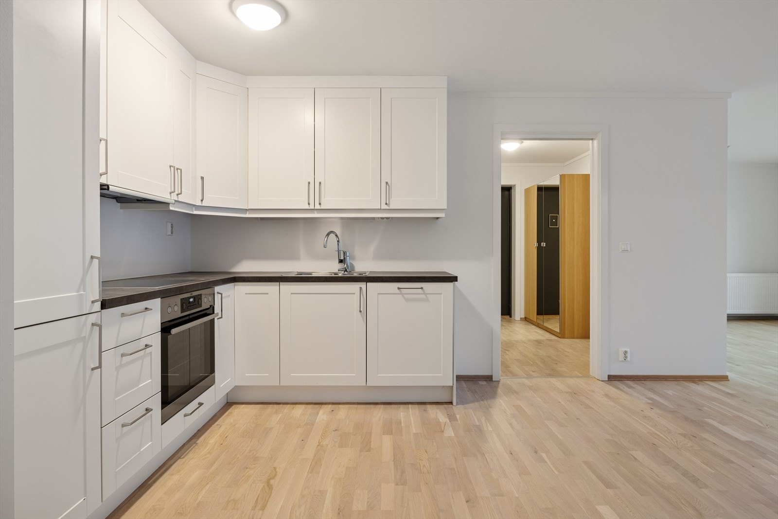 Her får du en åpen stue og kjøkkenløsning med god plass på kjøkken, samt til spise- og sittegruppe Galleribilde