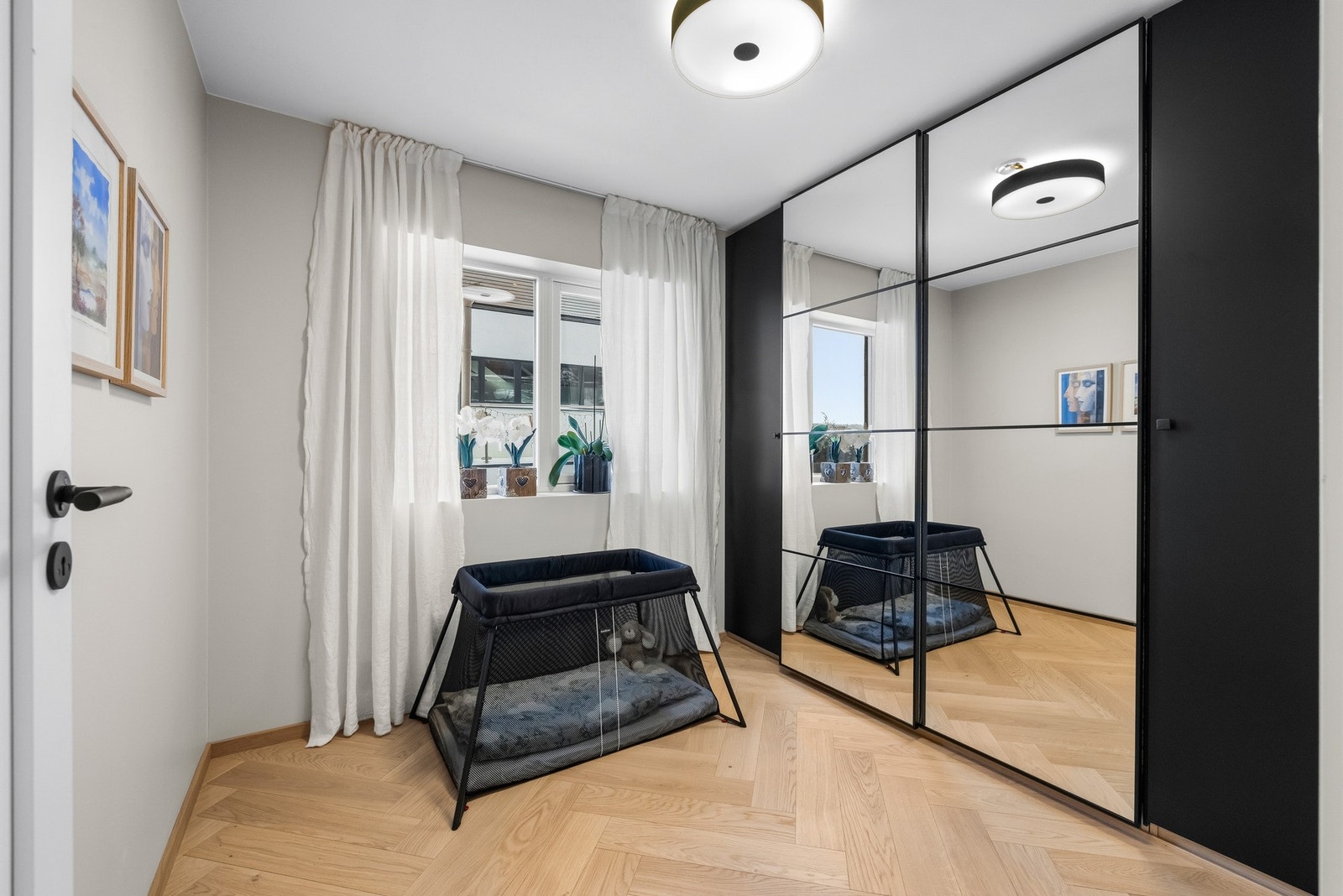 Vegg-i-vegg med hovedsoverommet ligger det naturlige barnerommet som er innredet med to sorte skap, montert på hver sin side av en stor skyvedørsgarderobe med speilfronter. Galleribilde