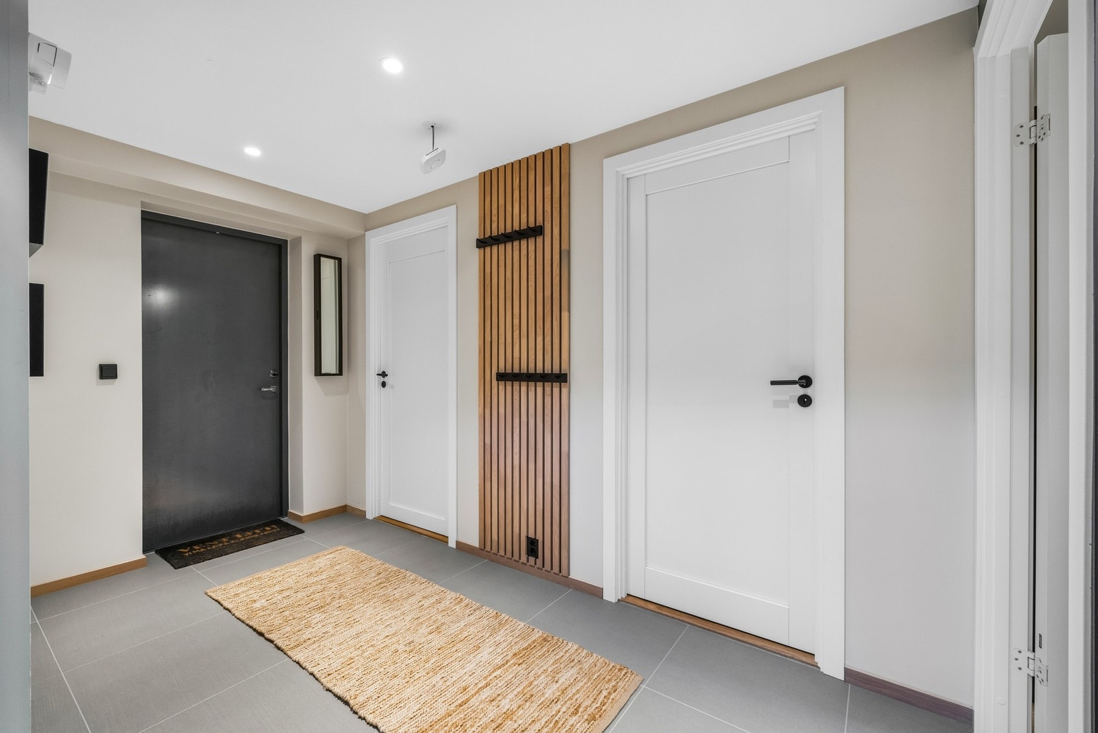 Løsningen gir en praktisk og skjermet inngang, ideell for hverdagsbruk, oppbevaring av yttertøy og enkel adkomst direkte fra garasje til bolig. Galleribilde