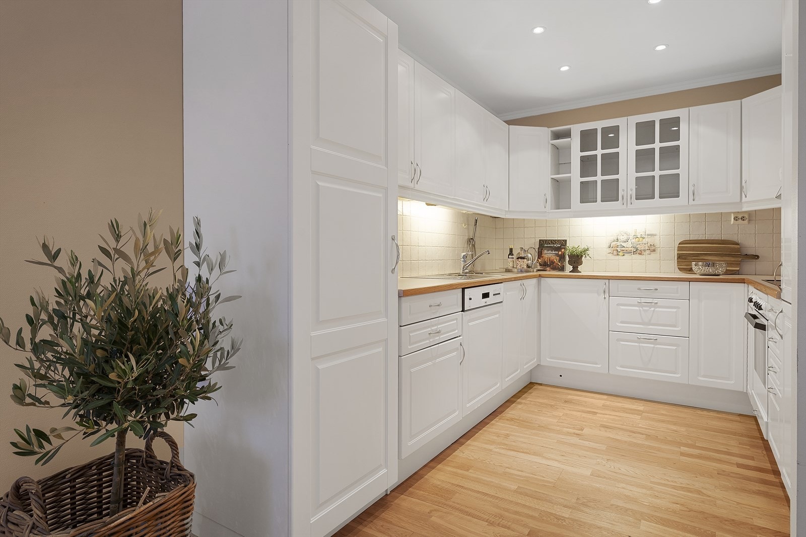 Hvitt pent kjøkken med integrerte hvitevarer. Galleribilde