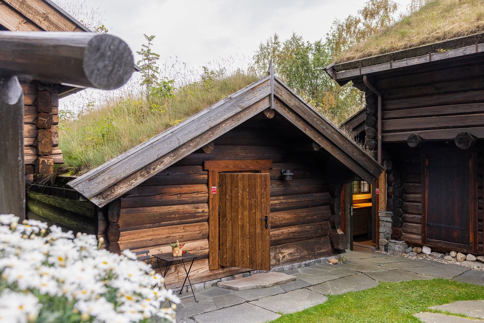 Det er lagt skifergulv med vannbåren bergvarme. Veggene er av laftet tømmer, og bygningen har åpen skråhimling med runde takåser Galleribilde